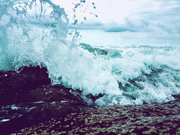 Close-up of waves splashing in sea against sky