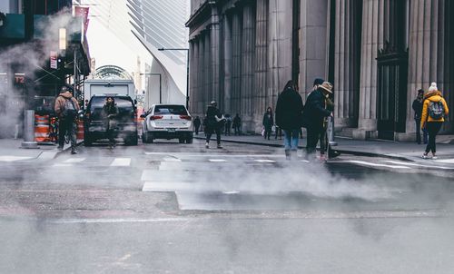 People on street in city against sky