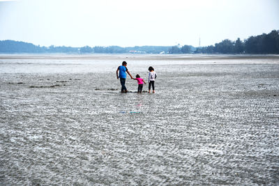 Rear view of people walking on land