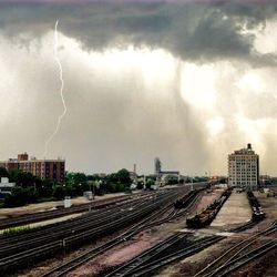 Railroad tracks against cloudy sky