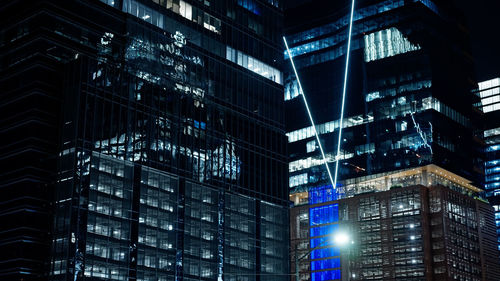 Low angle view of illuminated buildings in city at night