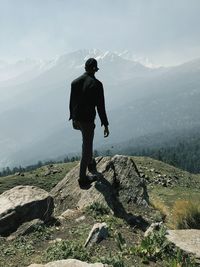 Man walking on rock against mountains