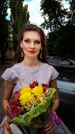 Portrait of smiling young woman with flower bouquet