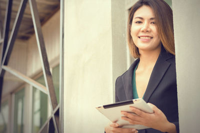 Portrait of a smiling young woman using mobile phone