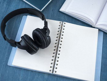 High angle view of book with headphones on table