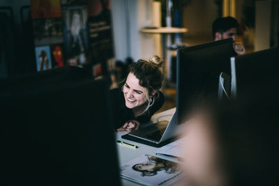 Young woman smiling while sitting at desk in office