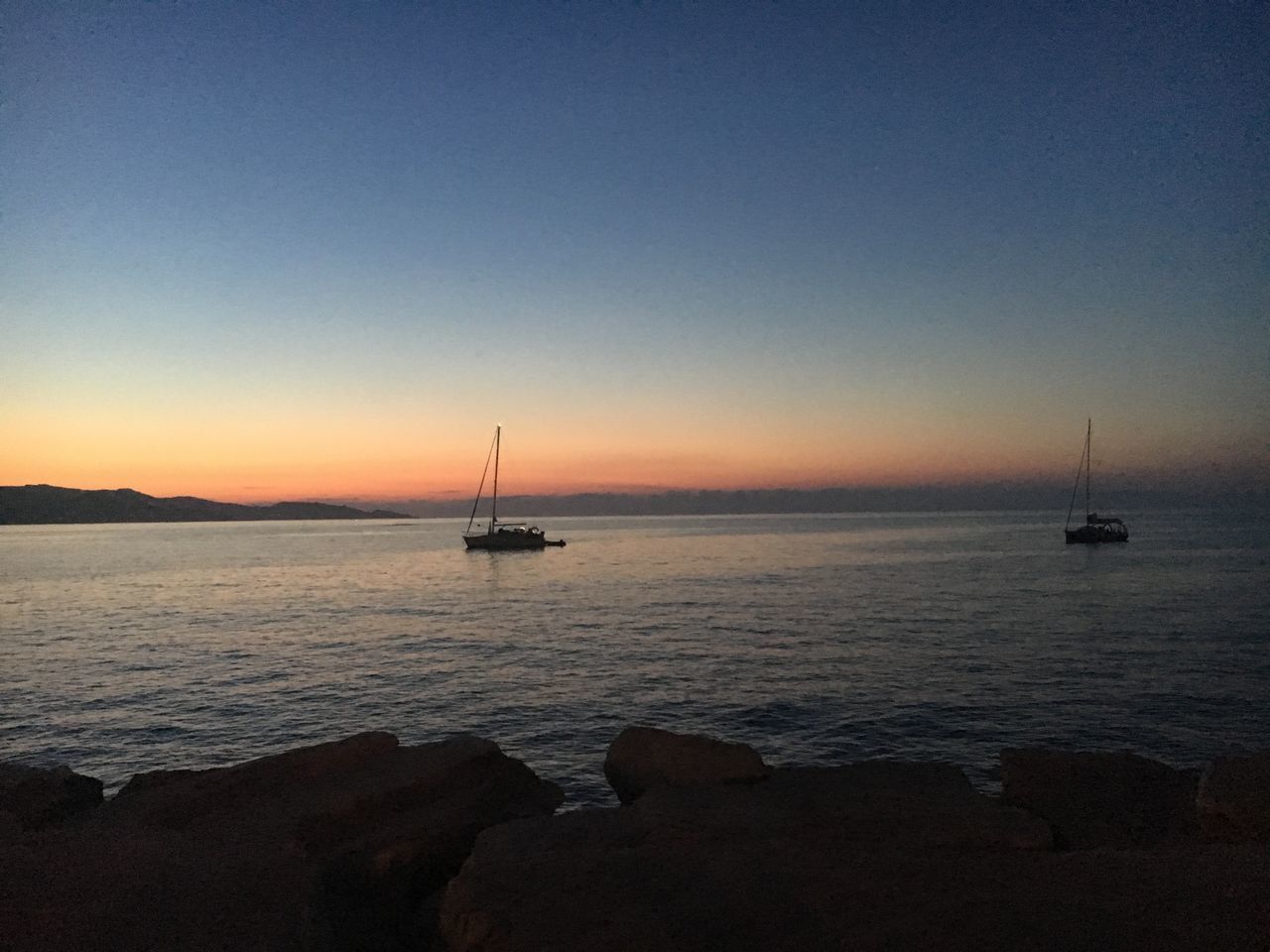 SAILBOATS IN SEA AGAINST CLEAR SKY DURING SUNSET