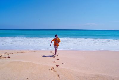 Full length of man on beach against sky