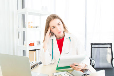 Young woman using phone while standing on table