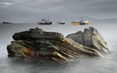 Rock at sea against sky