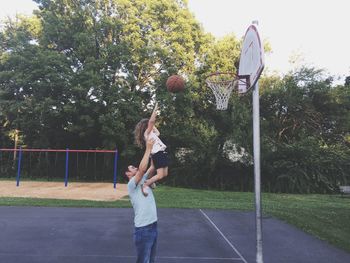 Father and daughter playing basketball