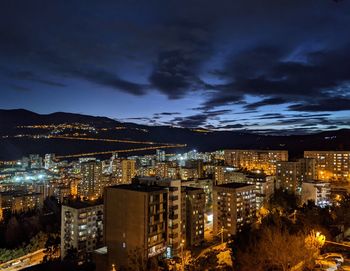 Illuminated cityscape against sky at night