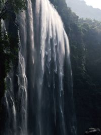 Scenic view of waterfall against sky