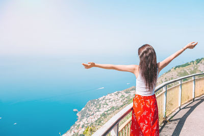 Rear view of woman looking at sea against sky