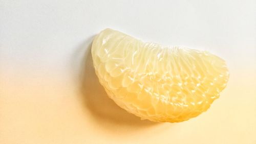 Close-up of lemon slice over white background