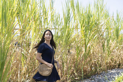 Portrait of smiling young woman standing on grass