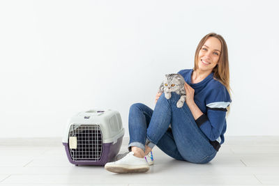 Portrait of a smiling young woman sitting on tiled floor