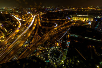 High angle view of illuminated multiple lane highway in city at night during monsoon