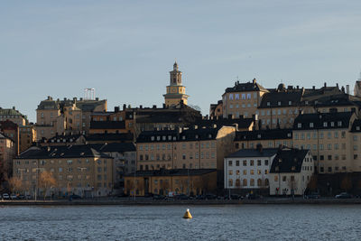 Buildings by sea against sky in city