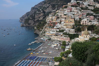 High angle view of townscape by sea against sky