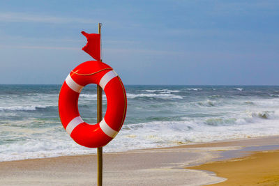 Red umbrella on beach against sky