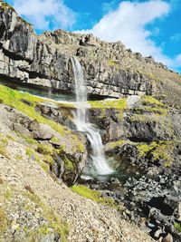 Scenic view of waterfall against sky