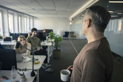 Manager looking at people working in office