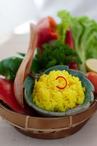 Close-up of nasi kuning in basket on table, indonesian traditional turmeric rice dish