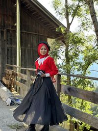 Portrait of young woman standing at the country side holding camera