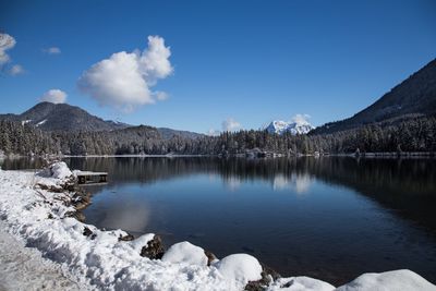 Scenic view of lake against blue sky during winter