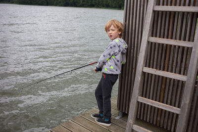 Portrait of boy on pier fishing lake