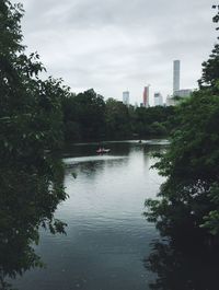 Scenic view of river by trees against sky