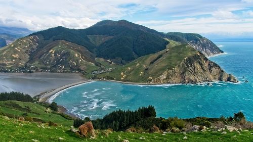 Scenic view of sea and mountains against sky