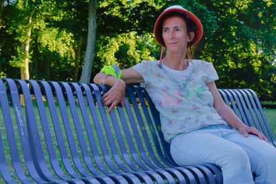 Portrait of smiling young woman sitting in park