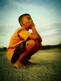 Boy on field against sky