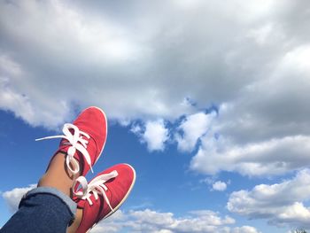 Low section person wearing shoes against sky