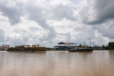 Scenic view of river by buildings against sky