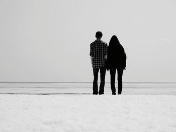 Rear view of couple standing on snow