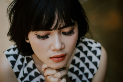 High angle close-up of young woman praying