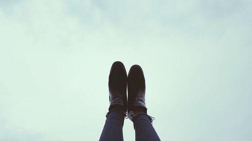 Low section of man standing against sky