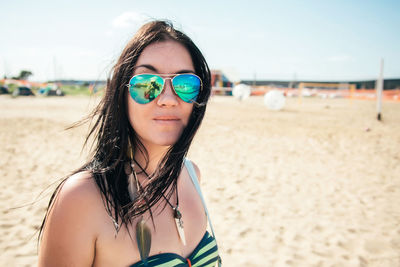 Portrait of young woman wearing sunglasses on beach