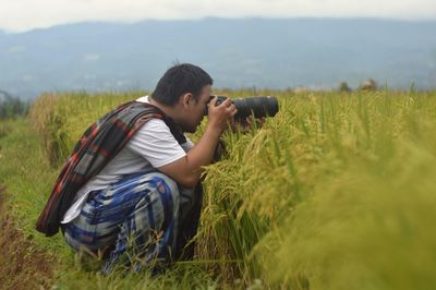 Man photographing on field