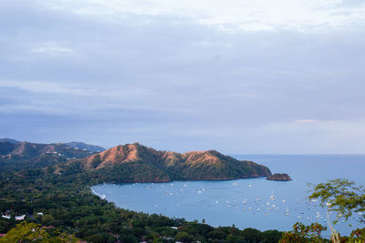 Scenic view of sea and mountains against sky