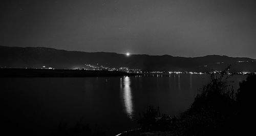 Scenic view of lake against sky at night