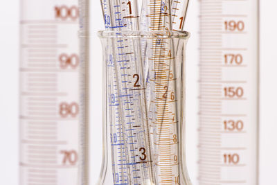 Close-up of empty beakers and flask against white background