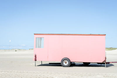 Vintage car on beach against clear sky