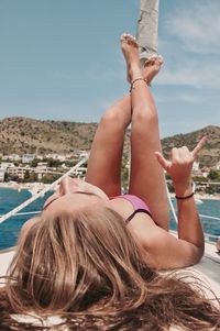 Midsection of woman relaxing on land against sky