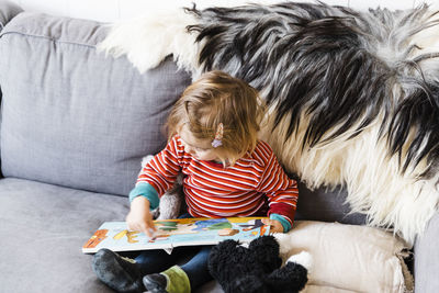 High angle view of girl playing on sofa at home