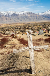 Wooden cross in desert against mountains