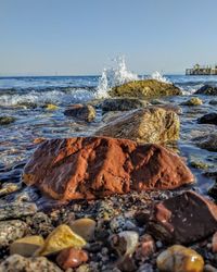 Scenic view of rocks on beach against sky